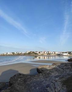 a beach with rocks and the water and houses at Appartement la Galerne Royan-Pontaillac - plage casino in Vaux-sur-Mer
