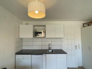 cocina con fregadero y microondas en Appartement Huez, 1 pièce, 4 personnes - FR-1-405-123 en L'Alpe-d'Huez