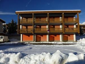 un edificio de apartamentos con terraza en la nieve en Appartement Huez, 1 pièce, 4 personnes - FR-1-405-123 en L'Alpe-d'Huez