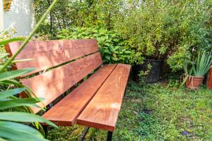 una panchina di legno in un giardino con piante di Im Rosengarten a Zell am Harmersbach