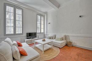 ein Wohnzimmer mit einem weißen Sofa und einem TV in der Unterkunft Le Pi-gnotte - Wi-fi - CENTRE VILLE in Avignon