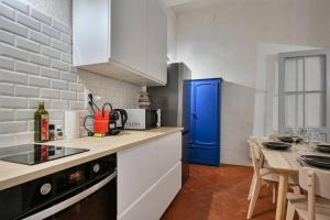 a kitchen with white cabinets and a blue door at Le Pi-gnotte - Wi-fi - CENTRE VILLE in Avignon