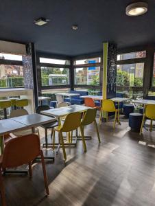 a dining room with tables and chairs and windows at ibis budget Saint-Omer Centre in Saint-Omer