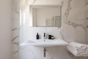 a white bathroom with a sink and a mirror at Vatican Family Loft in Rome