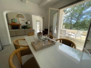 una sala de estar con una mesa con copas de vino. en La villa des Carriers- maison avec piscine proche mer, en Roquefort-les-Pins