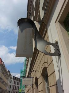 Ferienhaus im Barockviertel في درسدن: جرس معلق على جانب المبنى