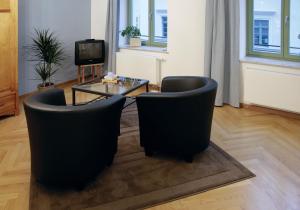 Ferienhaus im Barockviertel في درسدن: غرفة معيشة فيها كرسيين وطاولة وتلفزيون