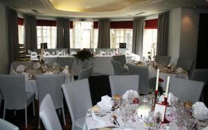 a dining room with tables and chairs with white tablecloths at Queen's Head Inn in Nassington