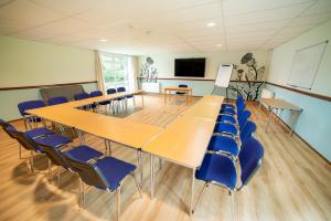 a conference room with wooden tables and blue chairs at Inverness Youth Hostel in Inverness