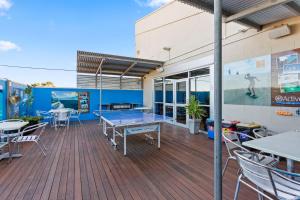 una terraza con mesa de ping pong y sillas en Port Lincoln Studio Apartments, en Port Lincoln