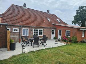 a patio with a table and chairs in front of a house at Ferienhaus Hanne Herrmann Hus in Esgrus