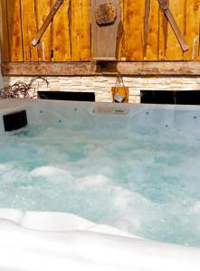 eine große Whirlpool-Badewanne mit Holzwand in der Unterkunft Maison jacuzzi-sauna Station 7 Laux in Theys + 29 Fotos