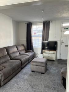 un soggiorno con divano e TV a schermo piatto di Crown Road Apartment a Kent