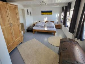 a bedroom with a bed and a wooden cabinet at Ferienhaus Hanne Herrmann Hus in Esgrus