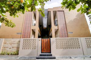 un edificio con una porta di legno di fronte di SPOT ON 92797 Awi Stay Syariah a Dumai