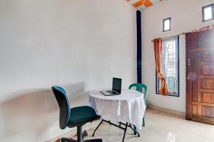 a room with a table with a laptop on it at SPOT ON 92797 Awi Stay Syariah in Dumai