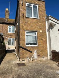 une maison en briques avec une fenêtre et une allée. dans l'établissement Crown Road Apartment, à Kent