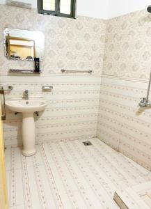 y baño con lavabo y espejo. en Evergreen Apartment, en Murree