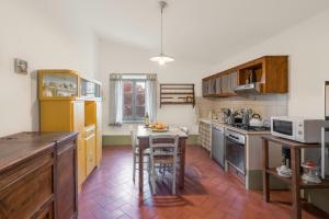 een keuken met houten kasten en een tafel. bij Podere Vallocchie in Sarteano