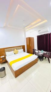 a bedroom with a large bed and a couch at Hotel Sunrise Palace in Udaipur