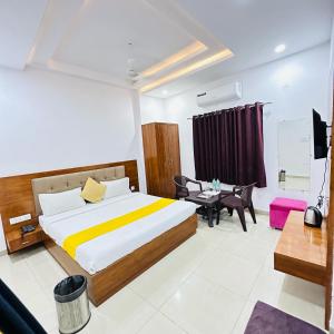 een slaapkamer met een groot bed en een bureau bij Hotel Sunrise Palace in Udaipur