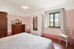 een slaapkamer met een bed, een dressoir en een raam bij Podere Vallocchie in Sarteano