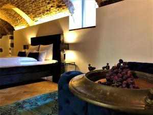 Historical Luxury Homes - Luxus Suite Colloseum في فريبورغ ام بريسغاو: غرفة مع وعاء من العنب في غرفة مع سرير