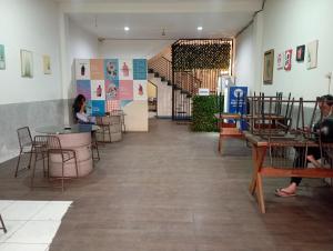 普禾加多的住宿－RedDoorz at Jalan Sudirman Purwokerto，一间设有桌椅的房间,以及坐在桌子上的人