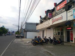 普禾加多的住宿－RedDoorz at Jalan Sudirman Purwokerto，停在商店外的一群摩托车