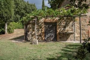 een stenen gebouw met een deur met wijnstokken erop bij Podere Vallocchie in Sarteano