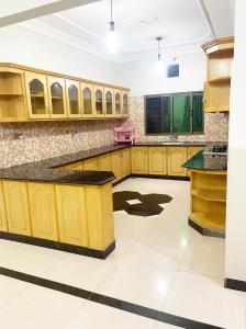a kitchen with wooden cabinets and a counter top at Evergreen Apartment in Murree