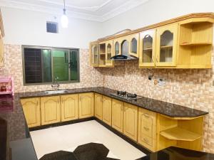 a kitchen with wooden cabinets and a black counter top at Evergreen Apartment in Murree