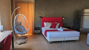 a bedroom with a bed and a hanging chair at Sea Holly Gozo in Nadur