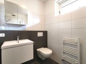 een witte badkamer met een toilet en een wastafel bij Cornfield in Arnhem