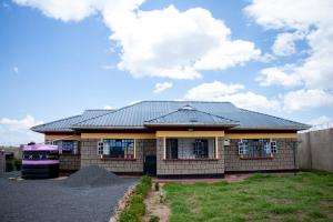 a house with a metal roof on top of it at The Country Side Villa - Nanyuki in Nanyuki
