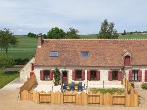 una casa con una valla de madera delante de ella en Les clés de la ferme - 4 chambres - proche La Loupe et Nogent-le-Rotrou - option SPA, en Sablons-sur-Huisne