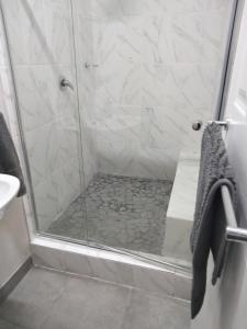 a bathroom with a shower with a glass door at Mila's place 35 Wellington Street in Cannonvale