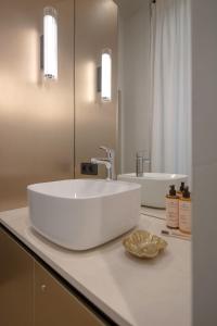 een badkamer met een grote witte wastafel op een aanrecht bij MiHotel Serlin in Lyon