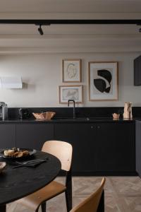uma cozinha com um balcão preto e uma mesa em MiHotel Serlin em Lyon