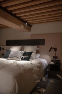 een slaapkamer met een wit bed en een houten plafond bij MiHotel Serlin in Lyon