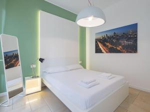 a bedroom with a white bed with a picture on the wall at Youhosty - Via Savona 70 in Milan
