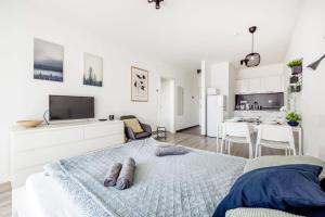a white bedroom with a bed and a living room at Modern Riverside Apartment with Free Parking in Budapest