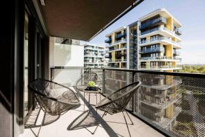 a balcony with two chairs and a table and a building at Modern Riverside Apartment with Free Parking in Budapest