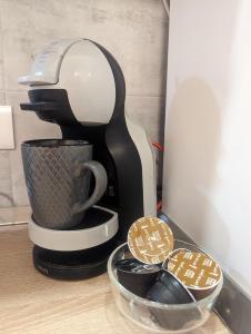 a coffee maker on a counter with a cup and cookies at Apartman Plasse in Rijeka