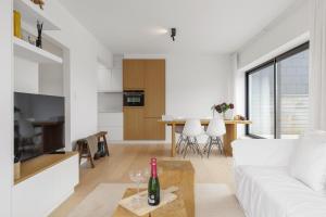 ein Wohnzimmer mit einem weißen Sofa und einem Tisch in der Unterkunft Julias Rooftop stay in Knokke-Heist
