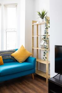 - un canapé bleu dans le salon doté d'une télévision dans l'établissement Belfast City - 3 Bed Cosy Terrace Home - Hip and Trendy Ormeau Road, à Belfast