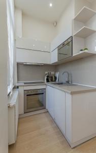 a kitchen with white cabinets and stainless steel appliances at Andrássy Str. Luxury Apartment in Budapest