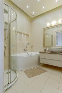 a bathroom with a shower and a tub and a sink at Andrássy Str. Luxury Apartment in Budapest