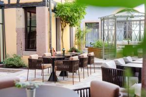 科爾馬的住宿－Hotel Le Colombier，餐厅内带桌椅的庭院