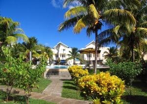 un complejo con piscina y palmeras en Villacool - Lot No 25 Residence Le Tamier, en Flic en Flac